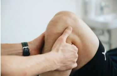 Doctor holding patient knee