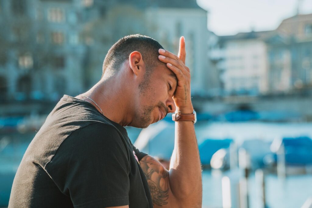 Man with a headache putting his palm on his forehead
